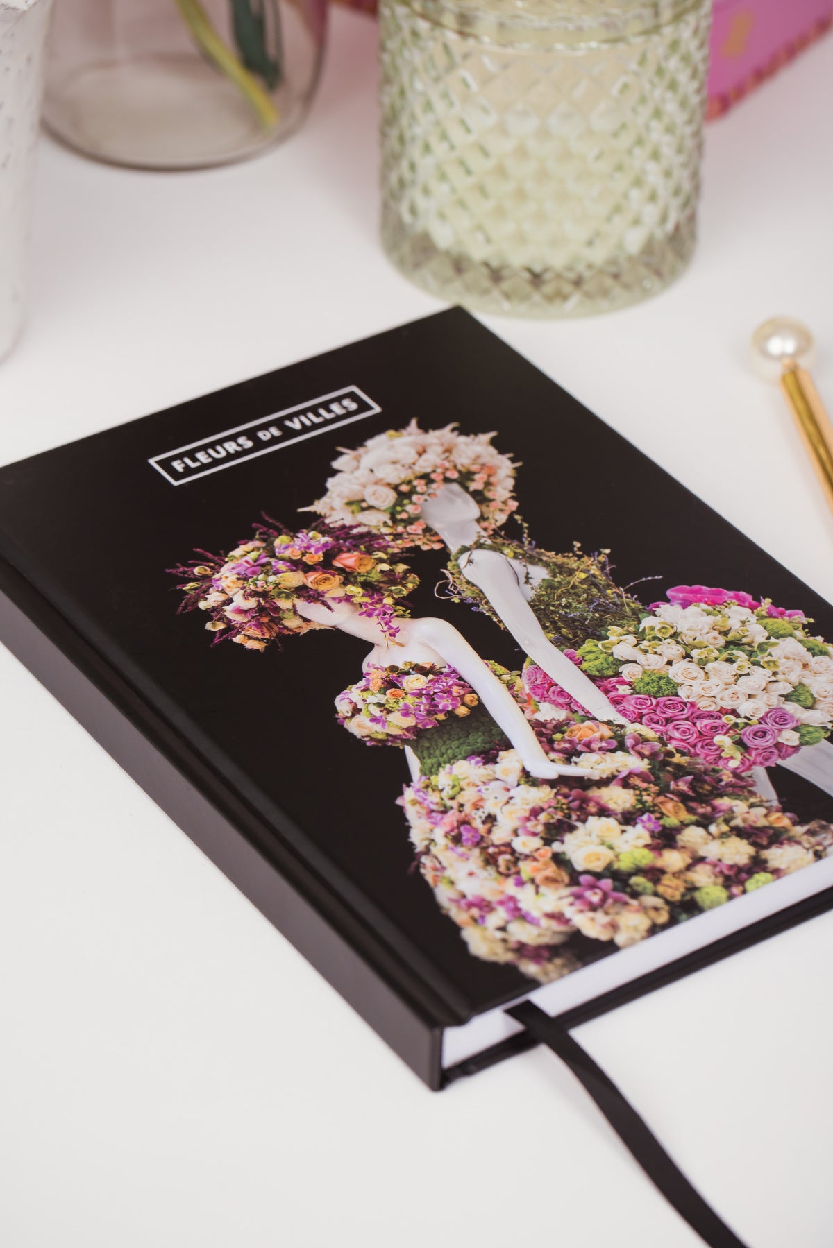 Floral-themed notebook with a woman's silhouette on a white surface