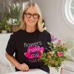 Tina Barkley wearing a black t-shirt with 'flowers make me happy' design, holding a potted plant.
